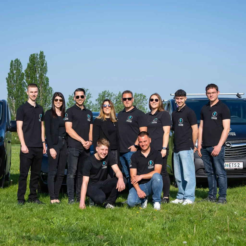 Das ET-Schuster Team vor seinen Firmenautos.